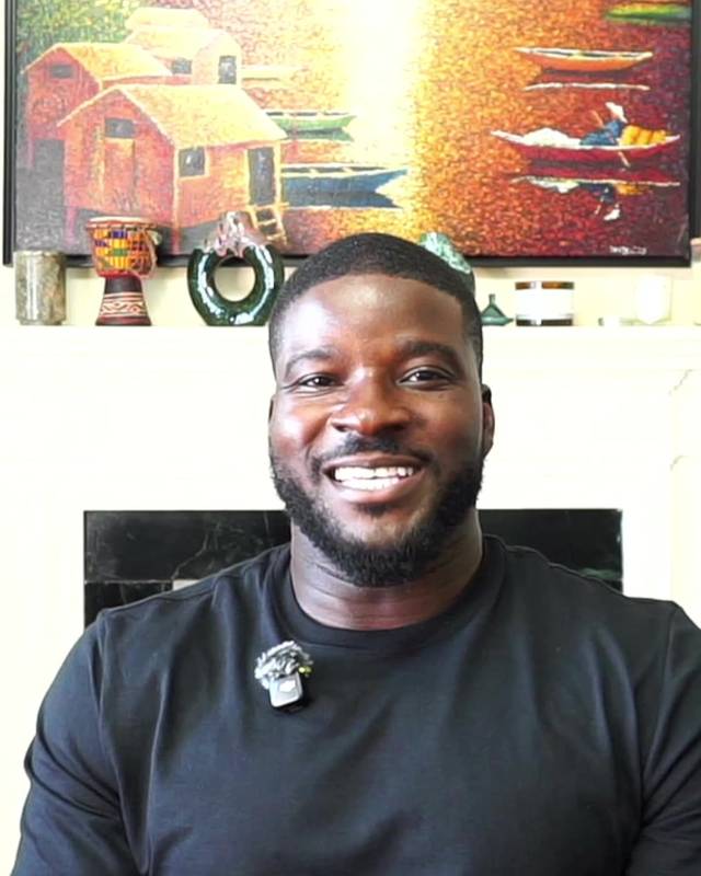 Olu, founder of WealthPocket, smiling at home in front of a colourful painting